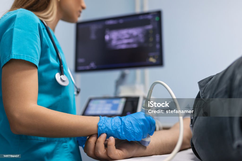 A sonographer performing a vascular ultrasound study.